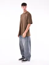 Remera blanca de corte oversized con logo pequeño estampado en el pecho.