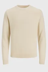 Sweater de punto color crema, de manga larga y cuello redondo.
