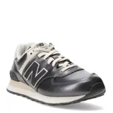 Championes New Balance modelo 574 Classics Traditionnels, color gris oscuro metalizado con detalles en beige claro. Presentan el logo 'N' en negro con borde beige y cordones color crema. La entresuela es beige con motas oscuras.