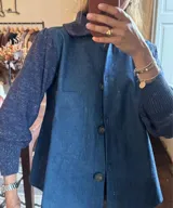Campera azul con mangas largas tejidas y cuerpo de denim con cuello clásico y cierre abotonado.