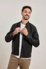 Campera de cuero ecológico color negro, con cuello mao y cierre frontal con cremallera metálica al tono.