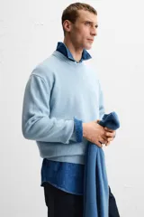Jersey celeste de cashmere y lana, de corte relajado, cuello redondo y manga larga con terminaciones en rib.