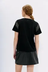 Remera blanca de lino con mangas cortas y calce al cuerpo. Presenta cadenas de strass en los hombros.