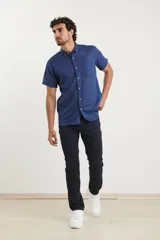 Camisa celeste de manga corta con cuello abotonado y bolsillo en el pecho.