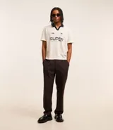 Pantalón de vestir marrón oscuro, de corte loose, con pliegues, bolsillos laterales y traseros.