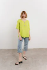 Blusa verde salvia de lino, con escote en V, manga corta y un botón de madera al frente.