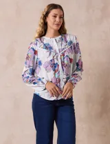 Blusa de gasa estampada con flores, marca Zac & Rachel. Tiene cuello a la base con abertura central con botones y mangas largas abullonadas.