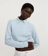 Blusa polo celeste de mangas largas confeccionada en tejido interlock compuesto por algodón BCI.