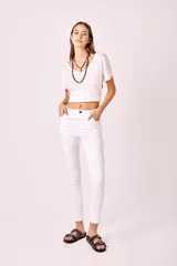Pantalón jean skinny blanco, tiro alto, con bolsillos delanteros y traseros.