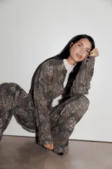 Pantalón recto de tiro medio-bajo con estampado animal print en tonos marrones y verdes.