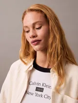 Camisa color crema de gasa doble, con cuello de punta, bolsillo de parche en el pecho, mangas largas con cierre de solapa enrollable y corte regular.