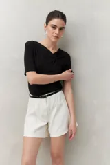 Remera negra de modal de manga corta con cuello asimétrico y detalle de nudo con frunces.