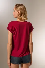 Remera manga corta color borgoña, de poliéster, corte al cuerpo y cuello buche.