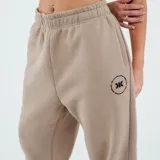 Pantalón de jogging color beige con puños elásticos y logo estampado en el muslo.