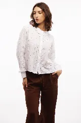 Camisa blanca de broderie de algodón, con cuello y mangas con volados.