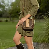 Bandolera de cuero color marrón con correa larga regulable, solapa con diseño trenzado y cierre con broche imantado.