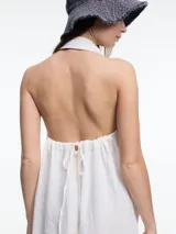 Vestido largo sin mangas confeccionado en lino, color azul, con cuello camisero y espalda descubierta con ajuste regulable.