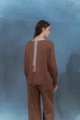 Sweater color beige de tejido de punto con brillo, escote en V y mangas largas.