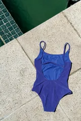 Traje de baño enterizo negro con escote en U, tiras finas y espalda redondeada. Sin almohadillas.