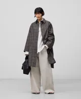 Gabardina larga a cuadros con cuello solapa, manga japonesa y cierre con botones.