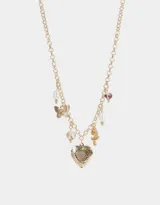 Collar corto dorado con cadena de eslabones y dijes colgantes: corazón labrado, mariposa, perlas, cuentas de cerámica con flores y moño.