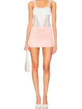 Body de encaje blanco con detalles en rosa, breteles finos y lazos laterales.