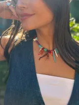 Collar corto con cuentas de resina, corales naturales, nácar, cuentas reconstituidas y cristales checos. Se cierra con cadena de acero quirúrgico y ganchito para regular el largo.