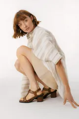 Sandalias de cuero color bordeaux con taco cuadrado y apliques metálicos dorados.