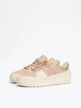 Zapatillas Tommy Hilfiger color crema y rosa pálido, con detalles dorados en el talón y logo de la marca en el lateral.