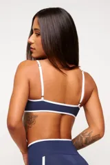 Top deportivo verde con detalles en blanco, logo minimalista y tirantes ajustables. Fabricado en poliamida y elastano con protección UV50+.