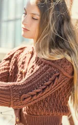 Cardigan marrón tejido a mano en lana merino, con mangas largas con trenzas 3D y botones de madera.
