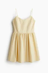 Vestido corto color crema, de algodón, con breteles finos, escote corazón, cuerpo entallado, espalda fruncida y falda con vuelo.