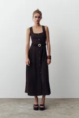 Vestido midi color marrón oscuro, sin mangas, con escote cuadrado, detalle de botones frontales y cinturón elástico con hebilla dorada.