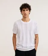 Remera blanca de algodón con textura de punto en líneas verticales, cuello redondo y mangas cortas.