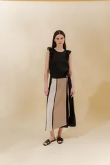 Falda midi de lino y algodón con paneles verticales en color beige, negro y tostado. Diseño portafolio con cruce, abrochada con botones y broches de presión regulables. Detalles desflecados en los cortes verticales y bolsillo escondido en el lateral derecho.
