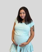 Vestido corto de algodón elastizado color celeste claro, diseñado para embarazo y lactancia. Presenta mangas cortas y una falda con volados. Posee una apertura sutil para facilitar la lactancia.