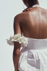 Top blanco de cuello halter y escote pico. Tejido combinado a tono. Bajo acabado tipo globo.