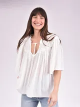 Blusa blanca de mangas cortas con escote en V y lazos.
