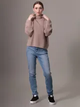 Sweater color beige de tejido de punto grueso con cuello alto y mangas largas.