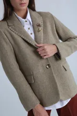 Blazer color camel de corte entallado, con solapas de muesca y cierre frontal con un botón.