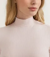 Blusa cropped de ribana color rosa claro, con cuello alto y mangas largas.