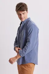 Camisa celeste de micropana con cuello abotonado, manga larga y bolsillo en el pecho.