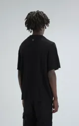 Camisa negra de tejido de punto calado con diseño de zigzag, cuello polo, manga corta y cierre frontal con botones.