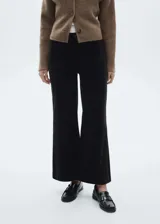 Pantalón de pana negro, de tiro alto y corte culotte. Presenta cierre de cremallera y botón, trabillas, dos bolsillos de parche delanteros y dos bolsillos de parche traseros.