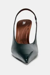 Zapato tipo slingback de tacón alto y fino, con punta afilada. El cuerpo del zapato es de charol verde oscuro, mientras que el tacón y el borde del talón son de color marrón.