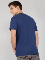 Remera azul de manga corta con cuello redondo y logo de Calvin Klein bordado en el pecho. Presenta una cinta distintiva en los hombros.