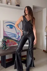 Pantalón Oxford negro de cuero sintético con cierre frontal y aberturas laterales con pasamanería plateada.