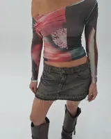 Minifalda de jean gris oscuro con efecto lavado, tiro bajo y ruedo desflecado.