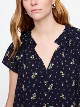 Blusa blanca de manga corta con escote en V y detalle de volados en el cuello.