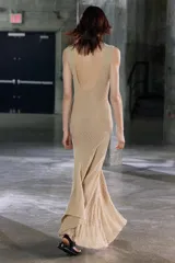 Vestido midi de encaje color beige, sin mangas, con espalda descubierta y bajo asimétrico con volados.